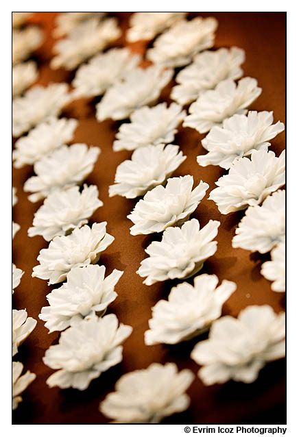 Porcelain flowers were placed on each table setting as a wedding favor to 